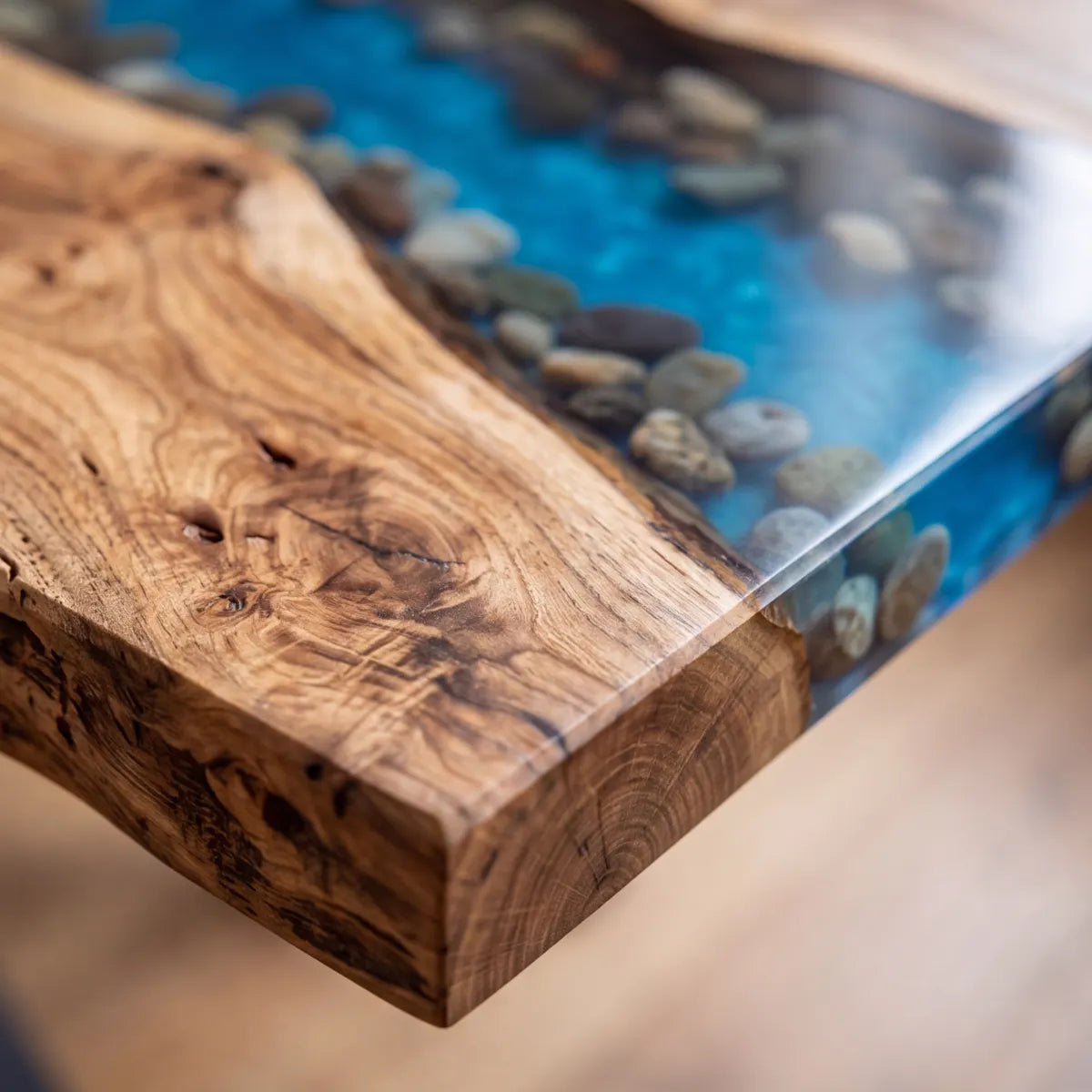 Close-up of Black Walnut live edge, clear blue epoxy, and embedded river stones